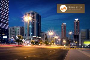 Orange Suites Hotel في المنامة: مدينة في الليل مع أضواء ومباني شوارع