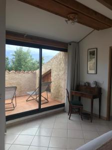 a room with a large window and a desk at A Muvrella in Pioggiola
