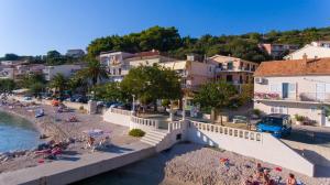 a group of people on a beach near the water at Apartments Lara in Podgora