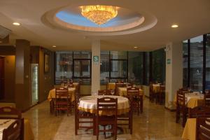 a restaurant with tables and chairs and a chandelier at Hotel Europa in Iquitos