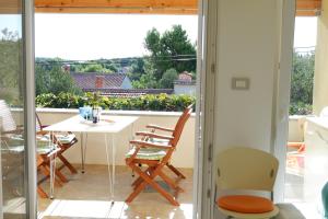 a room with a balcony with a table and chairs at Apartment Marija in Premantura