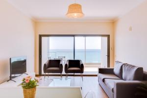 un soggiorno con divano e tavolo di Brisa do Mar 2Br - Sea front - Luxury apartment a Quarteira