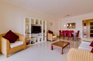 ヴィラモウラにあるAvelãs - Modern apartment - Vilamouraのリビングルーム(椅子、テレビ、テーブル付)