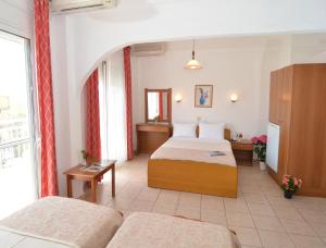 a hotel room with two beds and a window at Hotel TRIADA in Limenaria