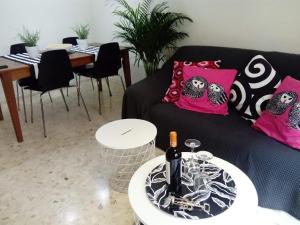 a living room with a black couch and pink pillows at Apartamento céntrico Torres de Quart. in Valencia