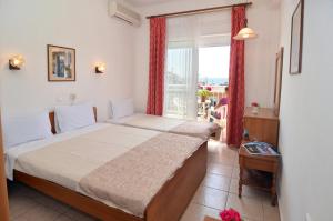 a bedroom with a large bed and a window at Hotel TRIADA in Limenaria
