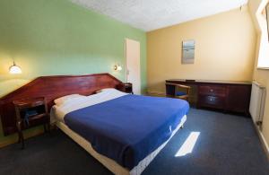 um quarto com uma cama e uma secretária e uma cama sidx sidx em Hotel de Champagne em Saint-Dizier