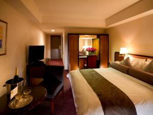 a hotel room with a large bed and a table at ANA Crowne Plaza Hotel Kyoto by IHG in Kyoto