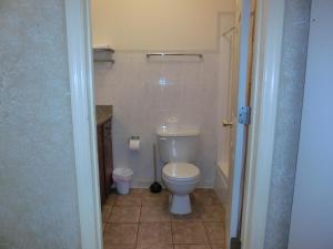 a bathroom with a white toilet in a room at The Garden Villas Hotel in Valdosta