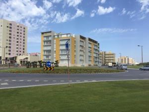a street with buildings and a street sign in the grass at Sun & Wave Apartment in Peniche