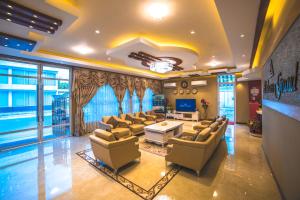 a large living room with couches and a tv at Abuharee Grand in Hithadhoo