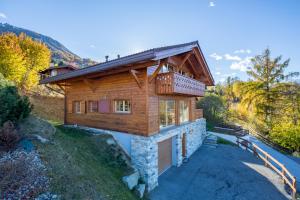 a log home with a porch on a hill at Chalet Freya in Nendaz