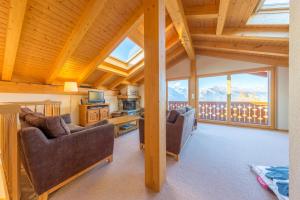 a log home living room with couches and a balcony at Chalet Freya in Nendaz