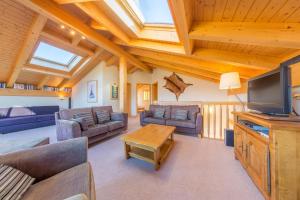 a living room with couches and a flat screen tv at Chalet Freya in Nendaz