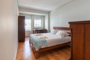 una camera con letto e testiera in legno di Go2oporto @Ceuta a Porto