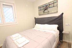a bedroom with a bed with white sheets and a window at El CONSEJERO de Indias free parking by Cadiz4Rentals in Cádiz