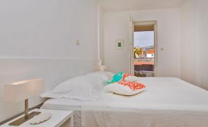 a white bedroom with a bed and a table at Dubrovnik Luxury Apartment Lapad in Dubrovnik