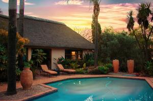 a swimming pool in front of a house at Lourie Lodge in Johannesburg