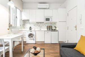 a kitchen and living room with white cabinets at BNBHolder CALLAO es MIA in Madrid