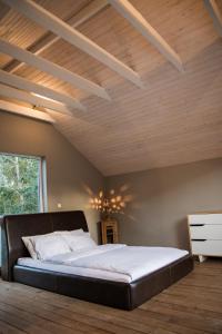 ein großes Bett in einem Zimmer mit Holzdecke in der Unterkunft Pape Rogas in Pape