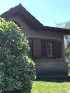 una casa con un arbusto delante de ella en Cabañas Luz de Luna en Santa Rosa de Calamuchita