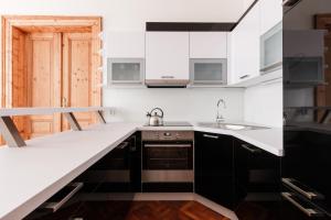 a kitchen with white and black cabinets and a sink at Stylish New Town Apartments in Prague