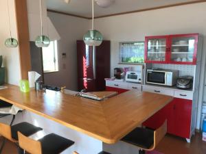 a kitchen with a wooden counter top and red cabinets at Ise Sky Villa / Vacation STAY 2021 in Sōchi