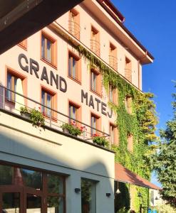 a building with a sign on the side of it at Hotel & Penzión Grand Matej in Banská Štiavnica