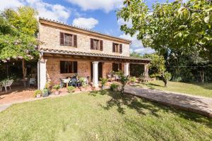 a stone house with a garden and a yard at Villa Agina in Algaida