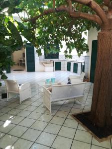 een patio met een tafel en stoelen onder een boom bij Casa TREND in Marina di Ragusa