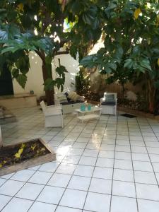 een patio met een boom en een tafel en stoelen bij Casa TREND in Marina di Ragusa