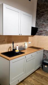 a kitchen with white cabinets and a sink at Apartamenty Równa in Kielce +15 photos