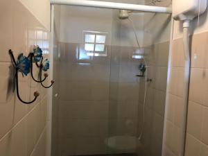 a shower with a glass door in a bathroom at Pousadinha da Praça in Conservatória