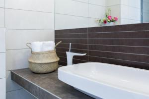 a bathroom with a tub and a basket of towels at Apartments Blue Maris Žnjan in Split