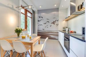 eine Küche mit einem Esstisch mit Fledermäusen an der Wand in der Unterkunft Le Meridien Apartment in Danzig