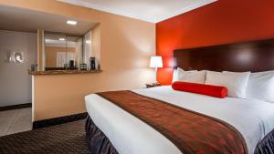 a hotel room with a large bed with a red pillow at Best Western Plus Casino Royale - Center Strip in Las Vegas