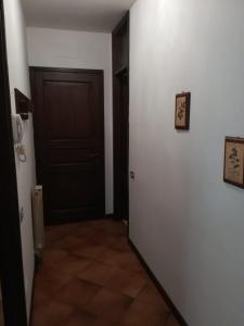 un couloir avec une porte et une chambre revêtue de carrelage. dans l'établissement Valsassina Rent, à Introbio