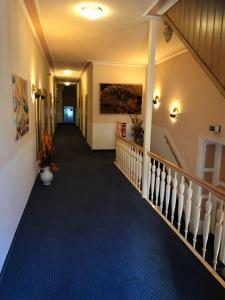 a hallway of a house with a staircase with blue carpet at Hotel Goldenes Schiff in Grimma