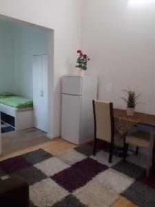 Una sala de estar con una mesa y un refrigerador. en Modernes Businessapartement, en Bietigheim-Bissingen