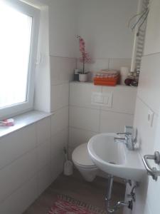 Un baño blanco con inodoro y lavabo. en Modernes Businessapartement, en Bietigheim-Bissingen