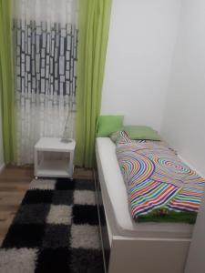 Un dormitorio con cortinas verdes y una cama y una mesa. en Modernes Businessapartement, en Bietigheim-Bissingen