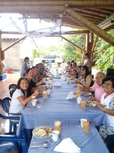 a group of people sitting at a long table at Finca Hotel La Cuyabrita in Pueblo Tapao