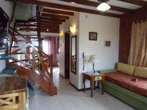 a living room with a couch and a table and stairs at Brisa Apart Valeria del Mar in Valeria del Mar +56 photos