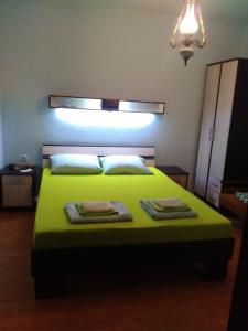 a bedroom with a green bed with two towels on it at Sobe Baosici Marina in Herceg-Novi