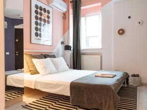 ein Schlafzimmer mit einem Bett und einer rosa Wand in der Unterkunft Universitate - Old Town Cosy Studio EQ in Bukarest