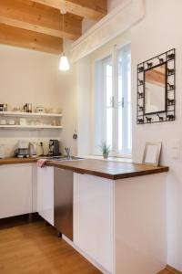 cocina con armarios blancos y encimera de madera en Sunny Apartments Vienna, en Viena