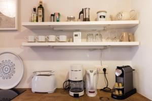 a kitchen with white shelves and a coffee maker at Sunny Apartments Vienna in Vienna