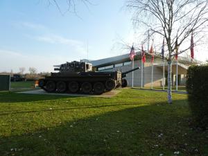 a tank on display in front of a building at LE BRIDGE in Bénouville