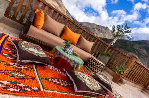 - un balcon avec des oreillers et un tapis sur un escalier dans l'établissement Riad Atlas Panorama, à Imlil