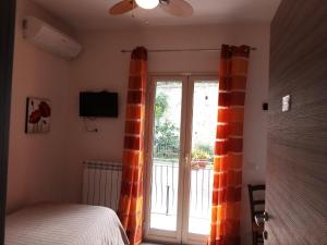 sypialnia z łóżkiem i przesuwanymi drzwiami szklanymi w obiekcie Bed & Breakfast Via Venezia w mieście Regalbuto